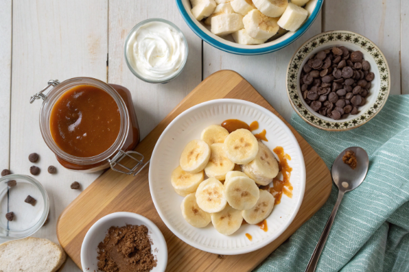 Ingredients and steps for creating a banana dessert, including bananas, caramel, and chocolate.